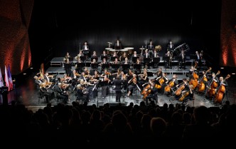 orkiestra siedząca na scenie 